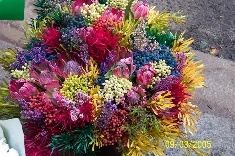A bright bouquet of pink, blue and yellow flowers at a market
