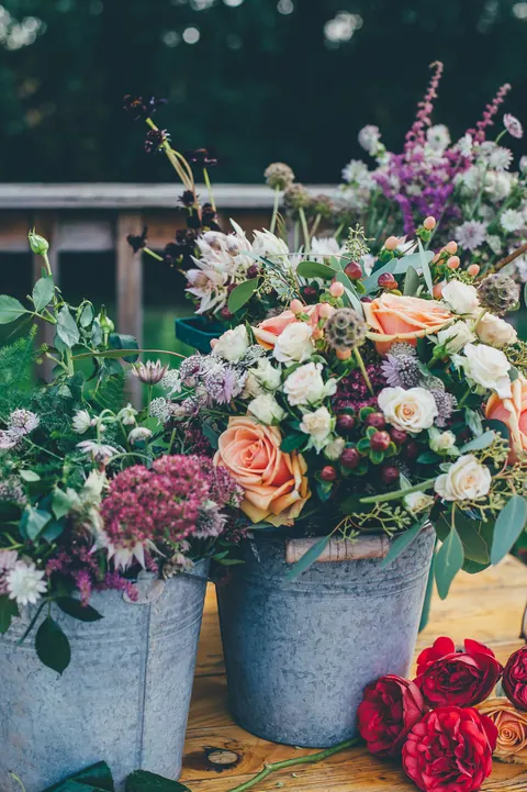 A metal bucket packed with mixed garden flowers